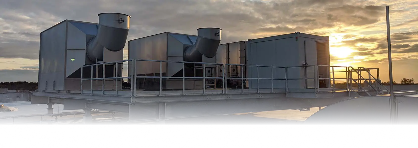 Containerised scrubber systems on a roof at dusk
